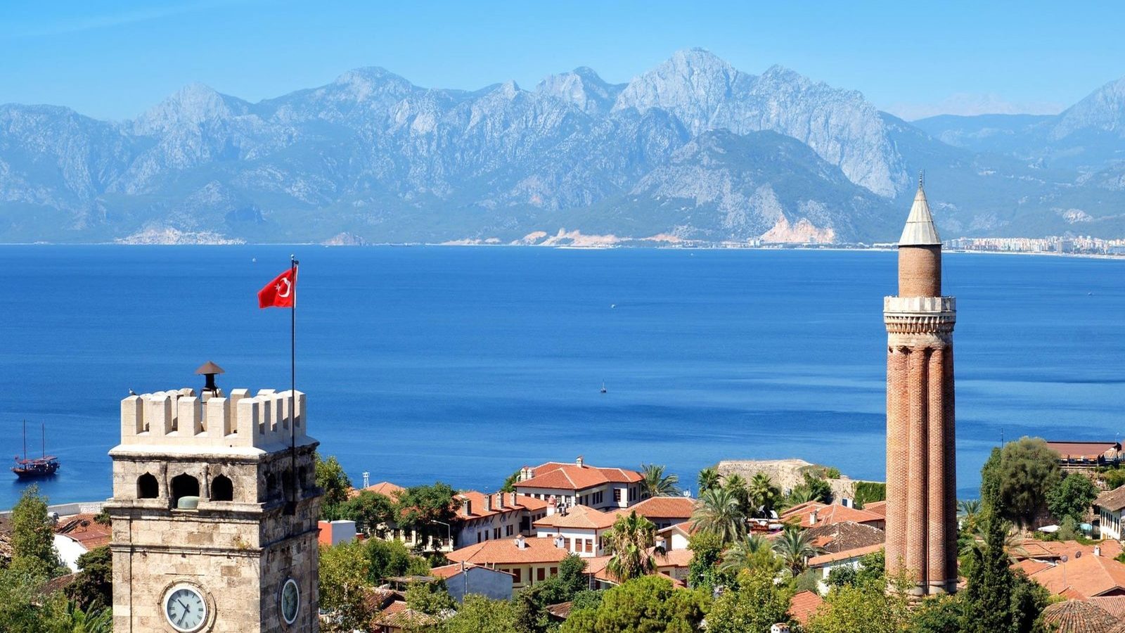 Antalya old town with its clock tower and fluted minaret, the Mediterranean and the Taurus Mountains behind